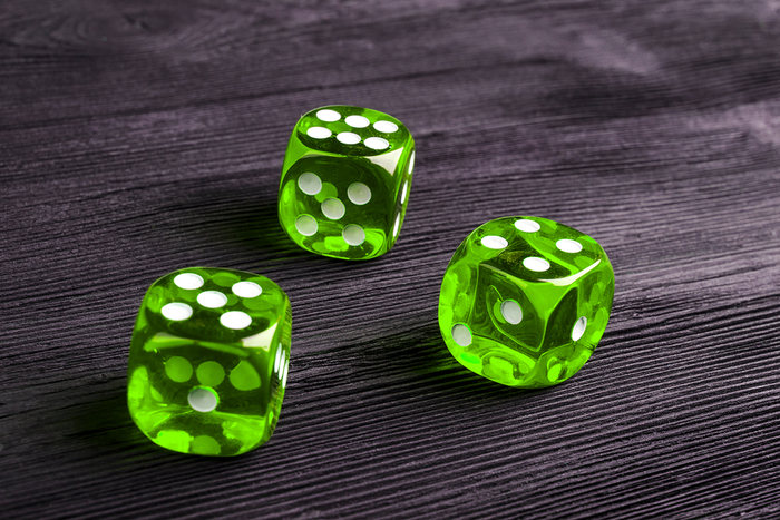 Green Dice on Wooden Table