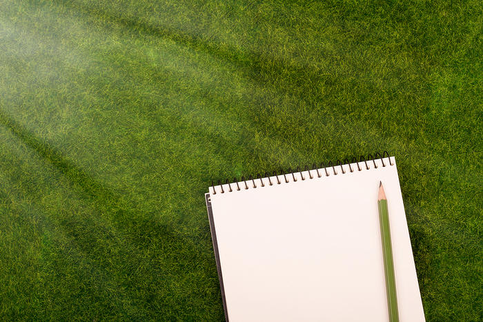 Notepad and Pencil on Grass