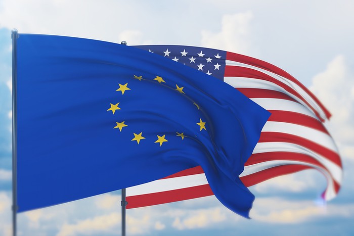 EU and USA Flags Against Cloudy Sky