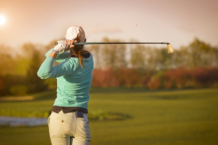 Female Golfer Playing at Sunset
