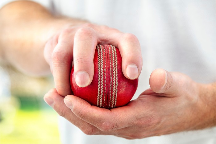 Cricketer Holding Ball Along Seam