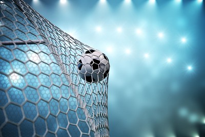 Football Hitting Net Against Bright Lights