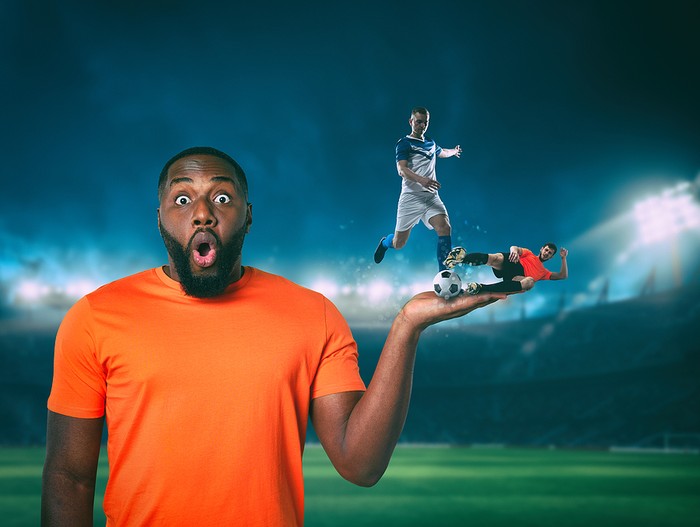Surprised Man with Footballers on Hand