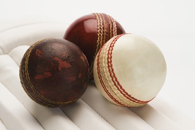 New and Old Cricket Balls on a Leg Pad