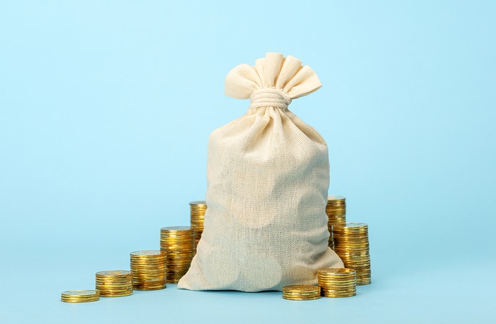 Money Bag and Coins Against Blue Background