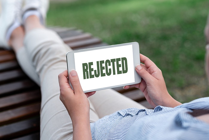 Woman Holding Smartphone Showing Rejected on Screen